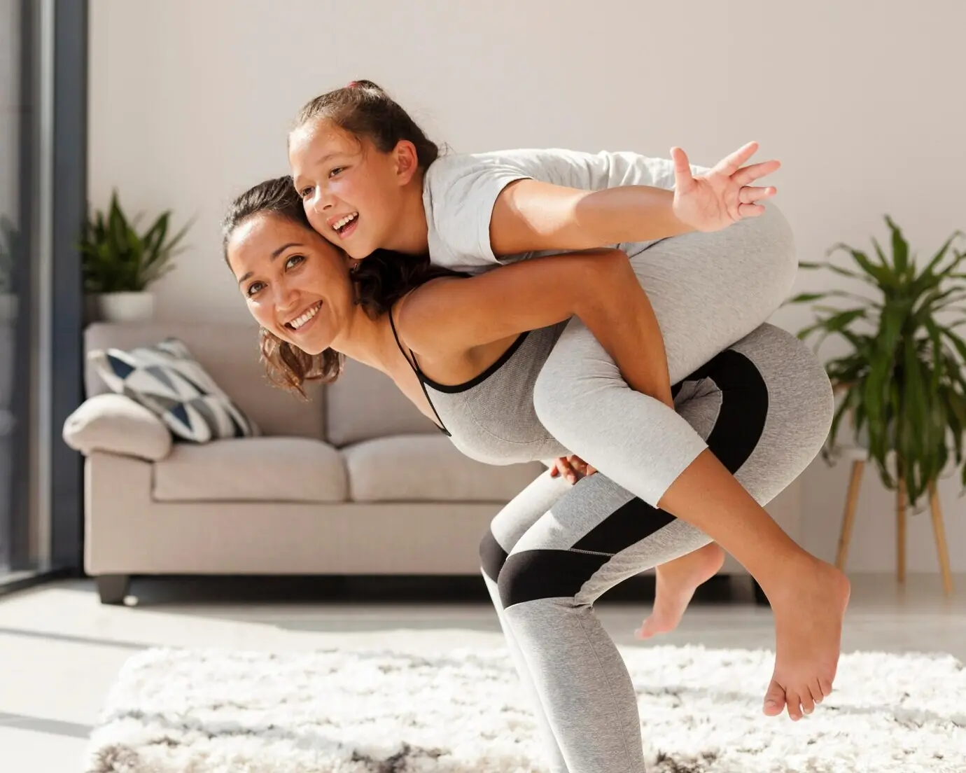 Seitenansicht einer lächelnden Frau, die ein Mädchen hält.